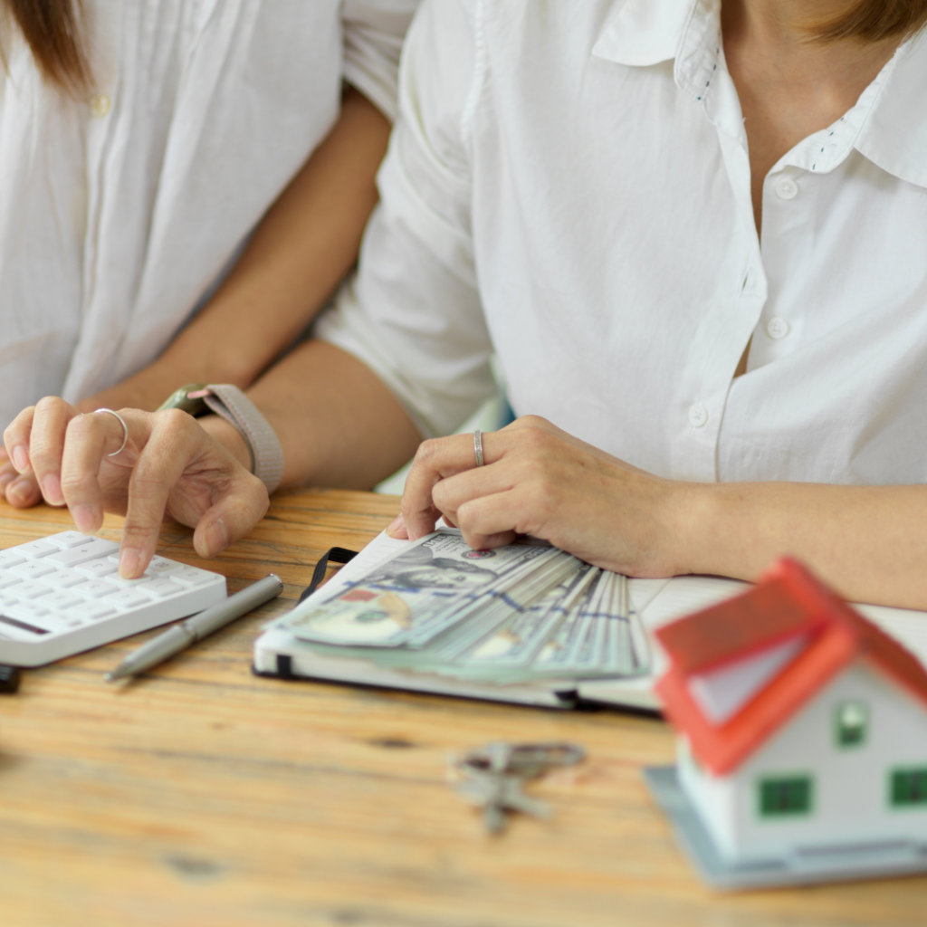 A picture of two homebuyers sitting at a table calculating their house down payment.