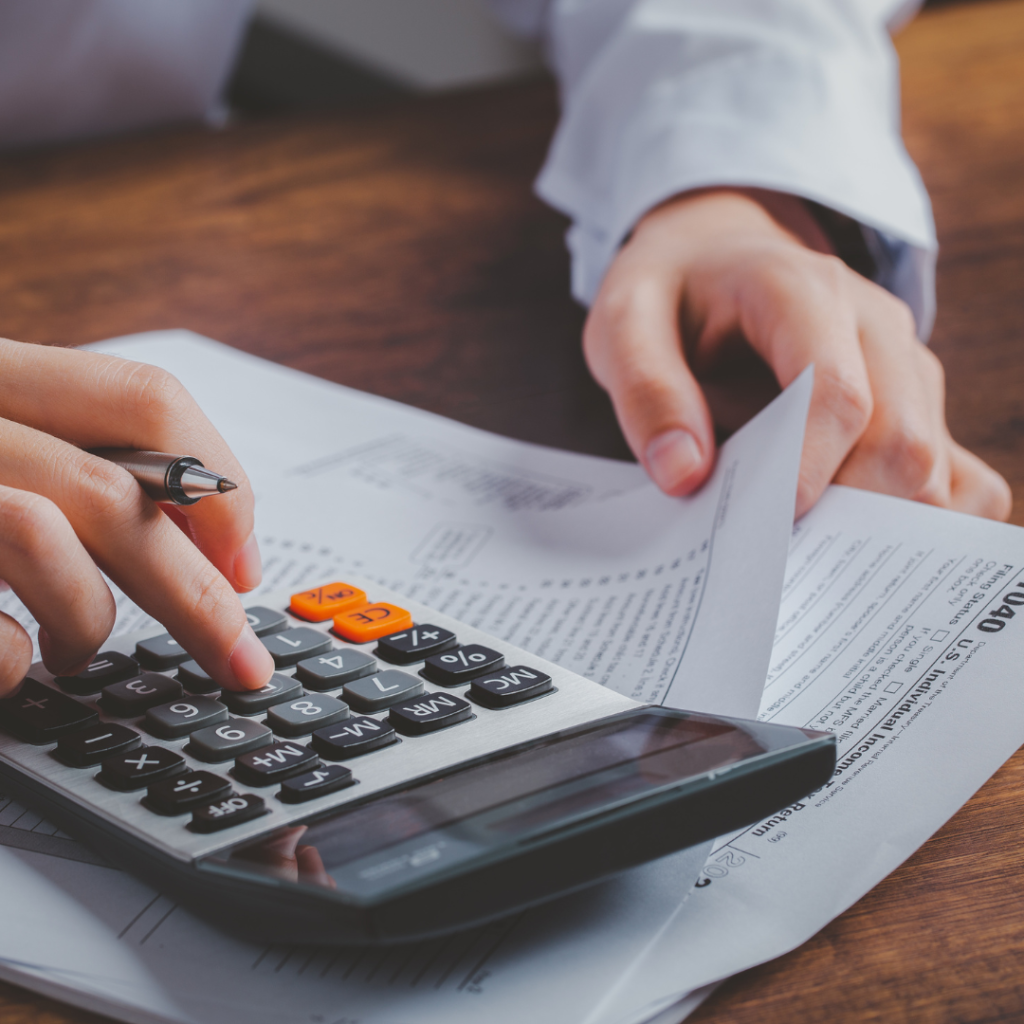 A picture of someone calculating their home loan while looking at their tax documents.