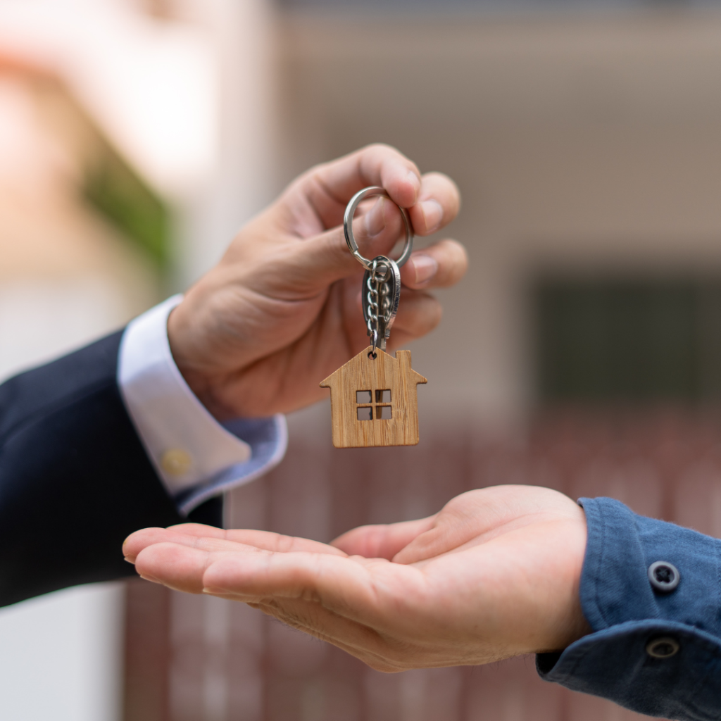 A picture of someone handing home keys to a first-time homebuyer.